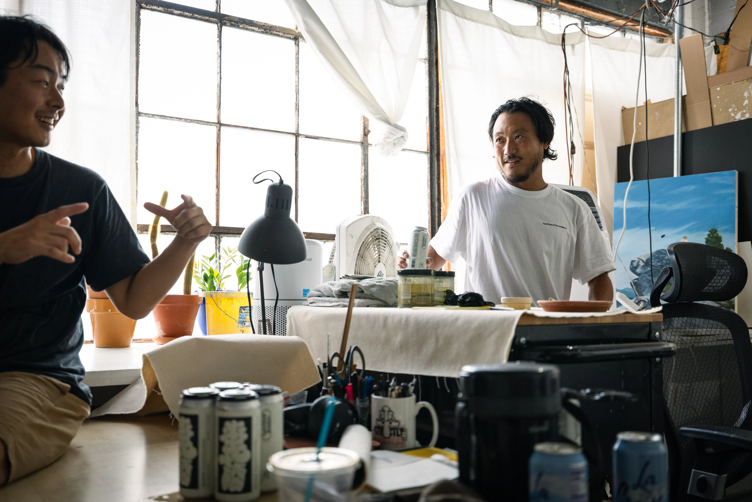 Artists talking together in a sunlit studio