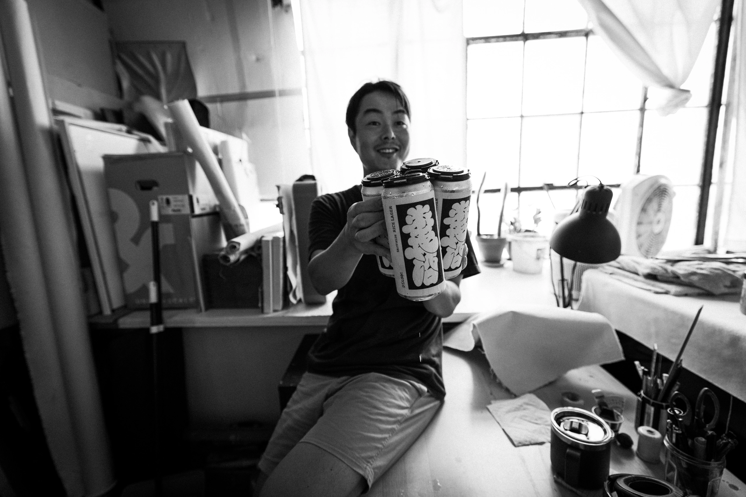 A person holding Saltfields cans in an artist studio