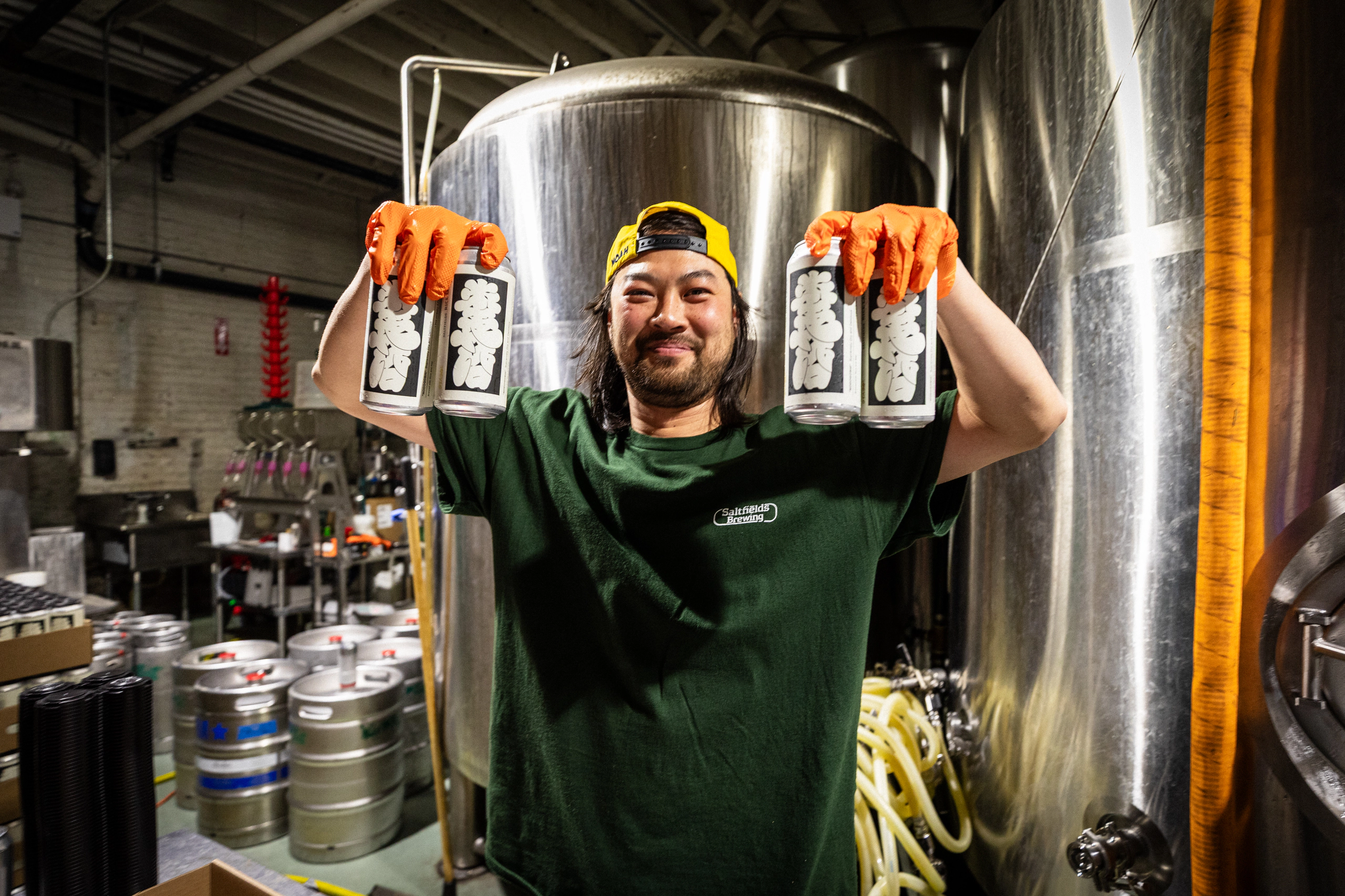 A brewer proudly holding two Saltfields cans