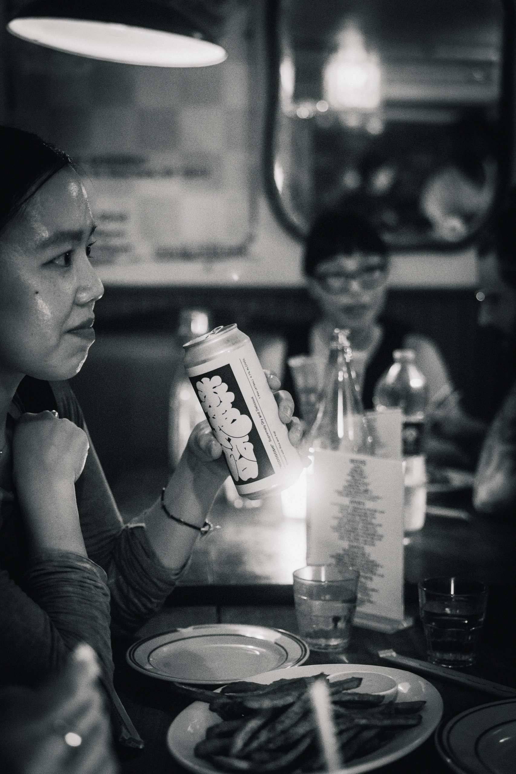 A guest holding a Saltfields can at dinner